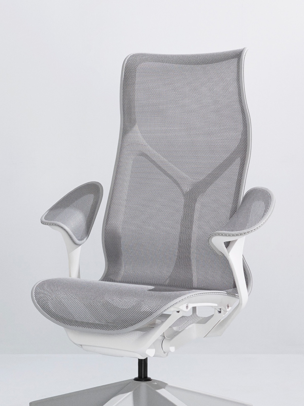 Une chaise Cinerm Mineral gris haut dossier avec un cadre blanc et des bras de feuille sur un fond gris clair.