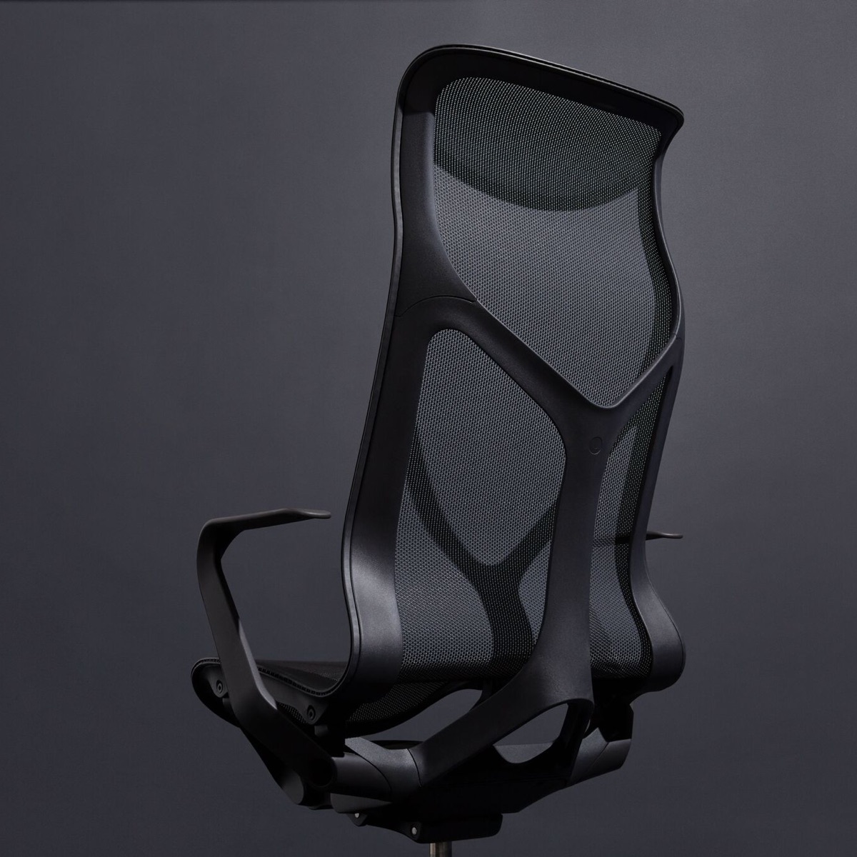 Une chaise Graphite gris foncé Cosm à dossier haut ergonomique avec bras fixes sur un fond gris foncé.